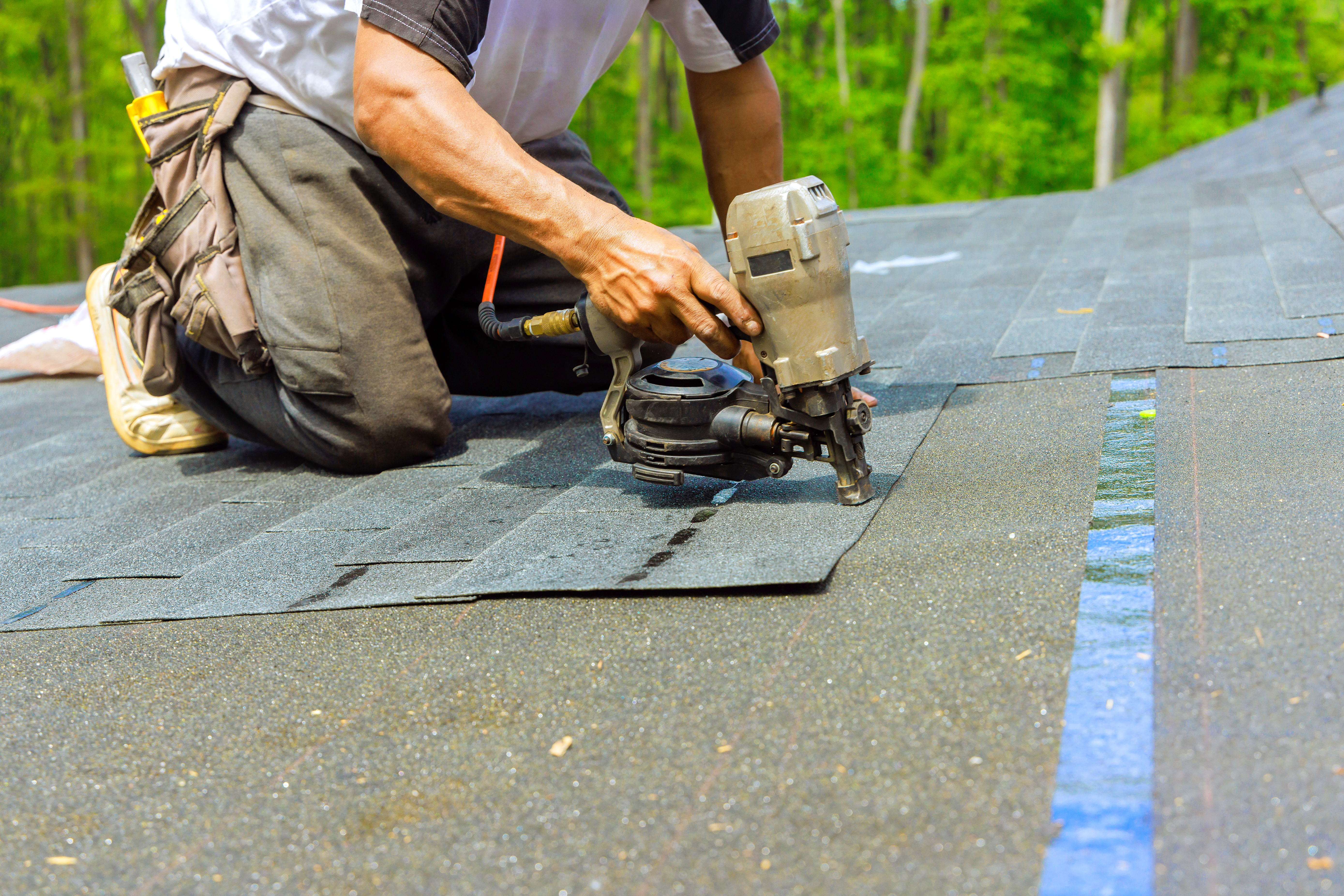 Roofer installing bitumen shingles